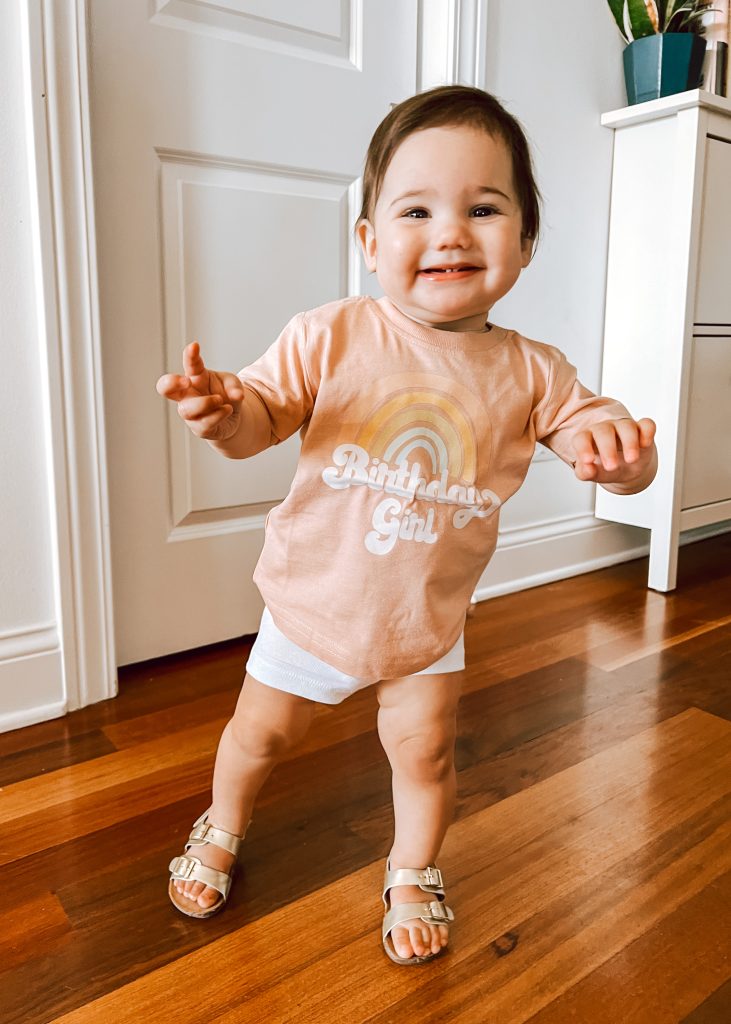 toddler standing and smiling